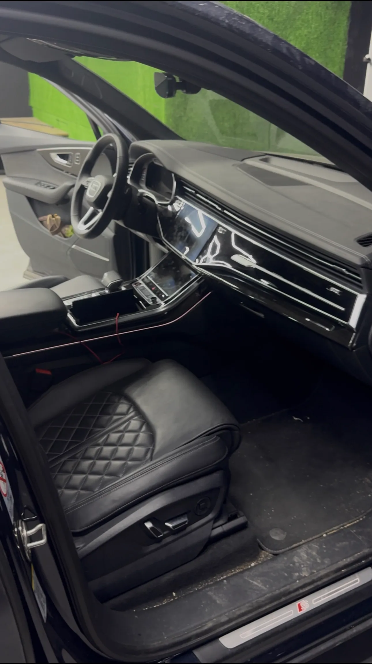 Interior de un Audi SQ7 antes — polvo y suciedad en la zona de los pies